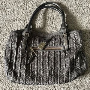 Gently used Silver Cole Haan shoulder bag. Beautiful raspberry silk inner lining